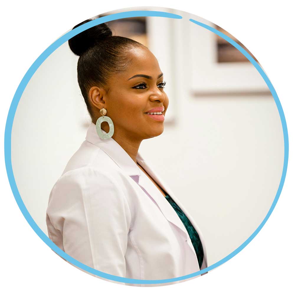 Proud smiling black woman in a medical setting wearing a medical coat