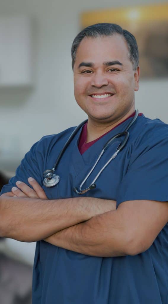 Hispanic-medical-assistant-standing-in-his-office